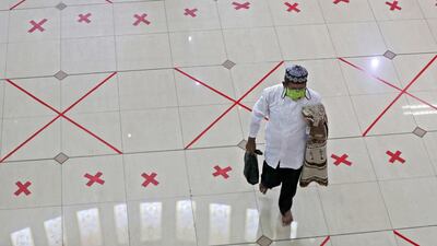 A man walks across marks used to space worshippers apart after Friday prayer at the Al Barkah Grand Mosque in Bekasi on the outskirts of Jakarta, Indonesia. AP Photo