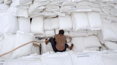 A worker unloads sacks of rice from a barge to a cargo ship on the Chao Phraya river in Bangkok. A total of around 500,000 tonnes of Thai rice shipments, mostly of parboiled grade for African buyers, have been delayed due to a labour shortage at ports. Athit Perawongmetha / Reuters