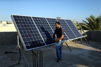 A man installs solar panels on a house in Khan Younis in the southern Gaza. Reuters