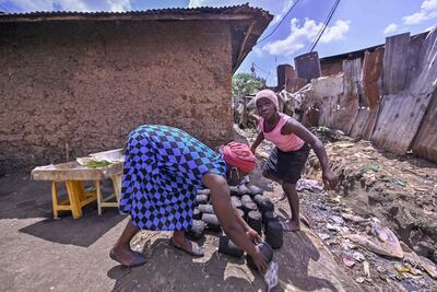 Bella Achieng (R), works with her mother Lilian Adhiambo at her open-air groceries stand near their home in Kibera slum, in Nairobi, on August 7, 2020, as schools remain closed across Kenya to curb the spread of Covid-19. Women tend to take on more unpaid care than men, according to a UN report. AFP