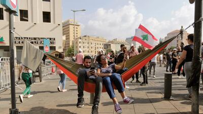 Anti-government protesters rest in a hammock hanging from a traffic sign post during a protest in Beirut, Lebanon, on October 19, 2019. AP Photo