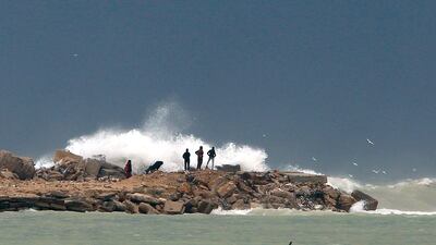 Palestinian residents of Gaza walk along the shore of the Mediterranean Sea. AP Photo