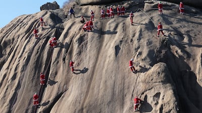 Mountain climbers in Santa Claus outfits scale Bukhansan mountain in Seoul, South Korea, during a charity event. Getty Images