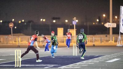 Players dash between the wickets during an absorbing street cricket contest.