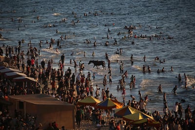 Palestinians cooling off on the beach at Nuseirat refugee camp in the central Gaza Strip. AFP