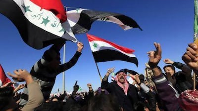 Sunnis in Iraq wave the old national flag during an anti-government demonstration in Fallujah on Friday.