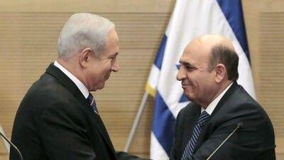 The Israeli prime minister, Benjamin Netanyahu, left, seals the new coalition deal with Shaul Mofaz, head of the centrist Kadima party, in Jerusalem yesterday. Ammar Awad / Reuters