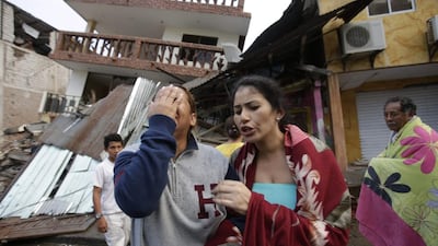 A woman cries as she stands next to house destroyed by the earthquake in the Pacific coastal town of Pedernales, Ecuador, on April 17, 2016 - one day after the strongest earthquake to hit Ecuador in decades flattened buildings and buckled highways along its Pacific coast. Dolores Ochoa/AP Photo