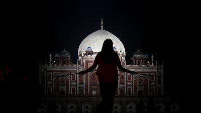 A visitor stands at a fence in front of Humayun's Tomb, a 16th-century Mughal monument in New Delhi, India. AFP