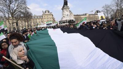 Demonstrators hold a large Syrian independence flag as they mark the fourth anniversary of the start of the Syrian conflict on March 14 in Paris. AFP Photo