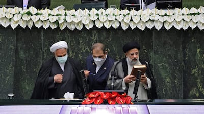 Iran's new President Ebrahim Raisi kisses the Quran as he takes the oath at the parliament in the Islamic republic's capital Tehran