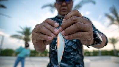 An angler secures a lure to his line.