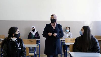 Students listen to their teacher during a lesson following the reopening of their school in Amman. Reuters