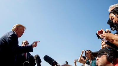 President Donald Trump, accompanied by Labour Secretary Alex Acosta, second from left, speaks to members of the media on the South Lawn of the White House in Washington on Friday. AP