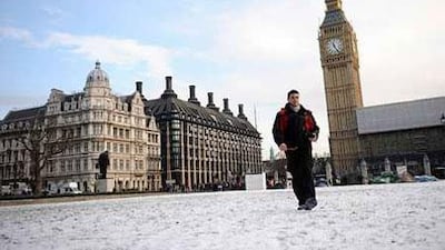 A man makes his way across a snowy Parliament Square in London.
