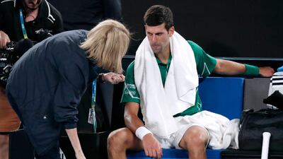 Novak Djokovic talks to a trainer. AP
