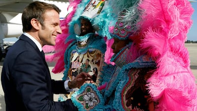 French President Emmanuel Macron is welcomed by members of the Crescent City All Star Band upon arrival at Louis Armstrong New Orleans International Airport in Kenner, Louisiana on December 2, 2022. - President Emmanuel Macron on Friday headed to the southern American city of New Orleans, which retains much of its French-infused heritage, as he wraps up a rare three-day state visit to the United States. (Photo by Ludovic MARIN / POOL / AFP)