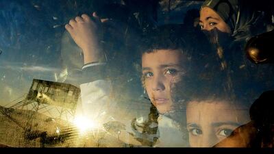 Syrian children look through their car window as they cross into Lebanon with their families at the border crossing, in Masnaa, eastern Lebanon. Hassan Ammar / AP Photo