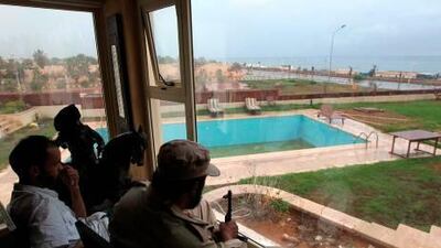 NTC fighters sit inside the beach house of Hannibal Qaddafi, son of Muammar Qaddafi, at the Regata beach compound near Tripoli. KARIM SAHIB / AFP PHOTO