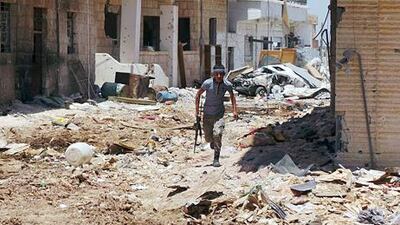 A lone Syrian rebel fighter runs through the streets of Daraa during clashes with government troops. The leader of the internationally recognised Syrian opposition implored any available Free Syrian Army units to head to Qusayr and reinforce rebel numbers.