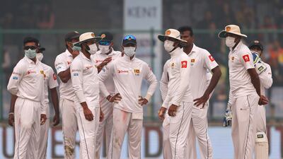 Sri Lanka's players gather wearing anti-pollution masks after the dismissal of India's Ravichandran Ashwin during the second day of their third test cricket match in New Delhi, India. Altaf Qadri / AP Photo