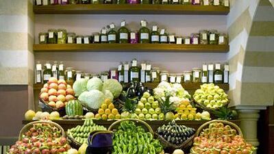 A grocer stocks tomatoes in a basket on display at Wafi Gourmet in Dubai Mall, one of the many high-end food stores in the emirate.