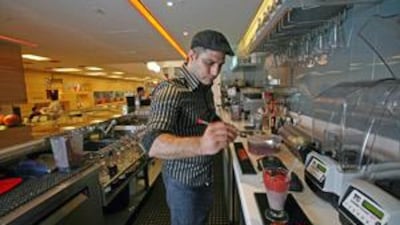 The mixologist Fadi Alia serves a National Sunrise smoothie at Waterlemon juice bar in the Dubai Mall.