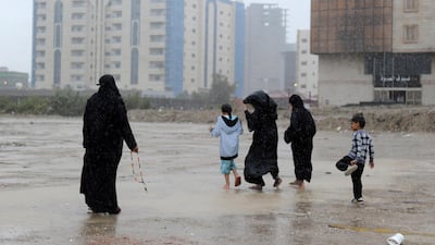 Saudi women and children cross a flooded street in Jeddah. Dozens of people were plucked from vehicles engulfed by floodwaters, Saudi civil defence authorities said, with heavy rainfall expected to last at least until Wednesday. Amer Hilabi / AFP Photo