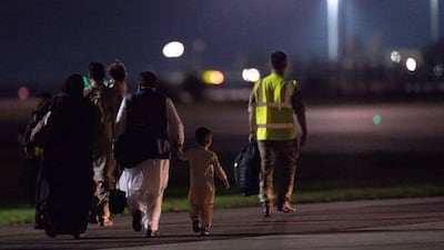British nationals and Afghan evacuees leave a rescue flight from Kabul at a UK military base in Brize Norton, England. Getty