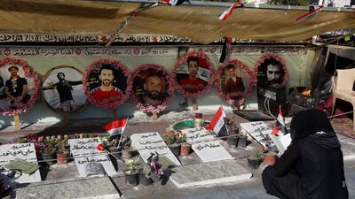 An Iraqi woman reads the Quran in front of the pictures of people who were killed during ongoing anti-government protests in Baghdad, Iraq. REUTERS