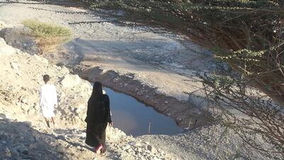 Azziz Al Yamahi, left, and Zainab Al Yamahi walk next to the well where their brother Sultan Al Yamahi drowned while trying to rescue Ahmad Al Samahi, 7. Ruba Haza / The National