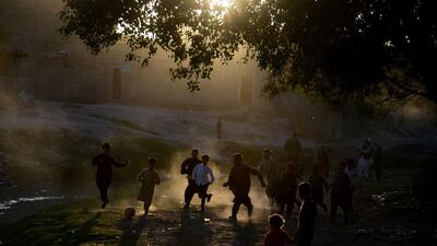 Afghan boys play football in a field in Herat. Football is a popular sport in the war-torn country. AFP