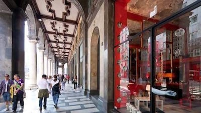 Shoppers stroll along porticoes in Piazza Filippo Meda in Milan, where many of Italy's most prestigious fashion labels can be found. Getty Images