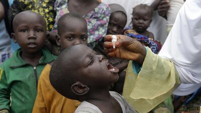 A health official administers a polio vaccine to children at a camp for people displaced by Islamist Extremist in Maiduguri, Nigeria. AP Photo