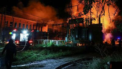 Rescuers in Kharkiv extinguish a fire after a rocket strike. EPA