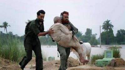 Pakistani army volunteers carry an elderly villager during an evacuation operation in Sanawan near Multan in central Pakistan yesterday.