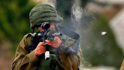 An Israeli soldier fires rubber bullets at Palestinian protesters during a weekly demonstration against the expropriation of Palestinian lands in the occupied West Bank, on February 1, 2019. AFP