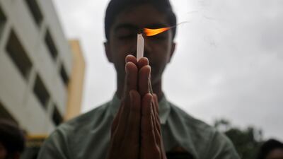 A schoolboy holds a candle as he prays inside a school in Ahmedabad, India, to pay tribute to Hindu pilgrims who were killed in a gun battle that erupted in Kashmir today. Reuters / Amit Dave