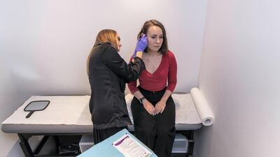Liz Cookman gets a piercing at the Maria Tash store in The Dubai Mall Antonie Robertson / The National