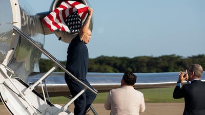 One of the 10 US citizens in an exchange between Washington and the Venezuelan government waves an American flag on arrival in San Luis Talpa, El Salvador. AFP