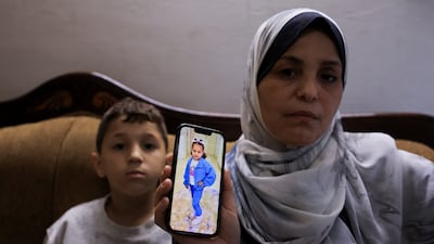 Hind Rajab’s grandmother shows a photo of her. Ahmed, her grandson, is sitting beside her. Reuters