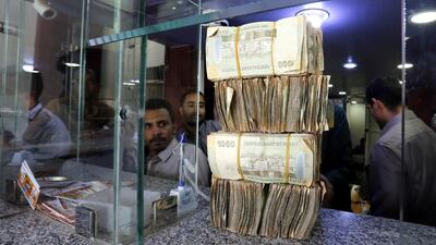 Yemenis exchange currency at an office in Sanaâ. According to reports, the Rial has lost more than 100 per cent of its value against the US dollar. EPA