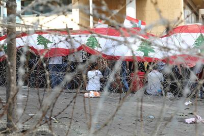 Demonstrators gather behind barbed wire protecting the government headquarters, known as the Grand Serail, in central Beirut on October 19, 2019. AFP