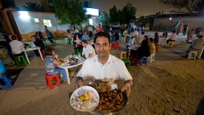 Haneefa displays a meal before serving it to a customer at Bu Qtair Cafeteria in Jumeirah.