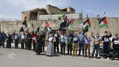 Mask-clad Palestinians demonstrate along the controversial separation barrier at the western entrance of the northern West Bank city of Tulkarem, marking the 72nd anniversary of Nakba. AFP
