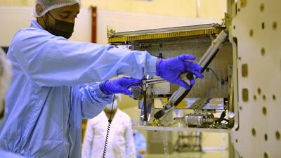 An engineer works on the satellite. Mbrsc