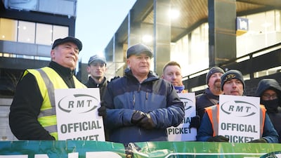 Mick Lynch, centre, general secretary of the RMT union, joins members on the picket line outside Euston station in London. PA