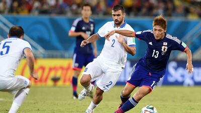 Japan forward Yoshito Okubo, right, dribbles away from Giannis Maniatis during their 2014 World Cup Group C match on Thursday. Toshifumi Kitamura/ AFP