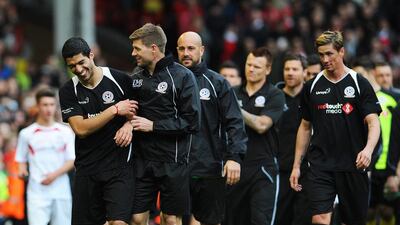 Steven Gerrard, second left, and Luis Suarez, left, share a joke at the end of the game. Peter Powell / EPA