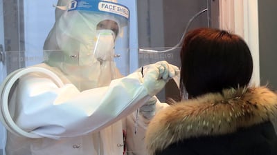 A medical worker takes a sample at an outdoor Covid-19 testing station in Seoul, South Korea. EPA